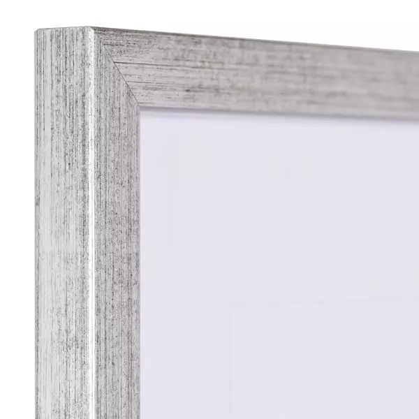Ansicht der Ecke eines schmalen, silberen Bilderrahmens mit sichtbarer Holzstruktur und glatter Oberfläche