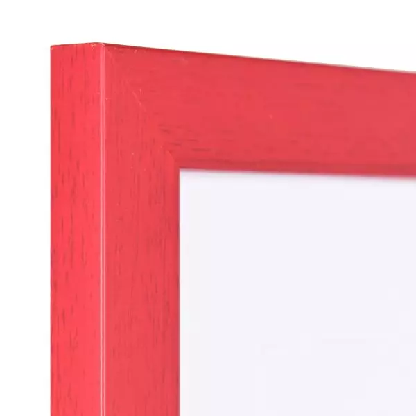 Ansicht der Ecke eines roten Bilderrahmens mit sichtbarer Holzstruktur, glatter Oberfläche und kantigem, schlichtem Profil